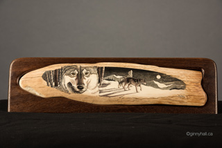 A scrimshaw peice by Ginny Hall 						 		depicting wolves.