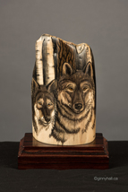 A scrimshaw peice by Ginny Hall 						 		depicting two wolf faces.